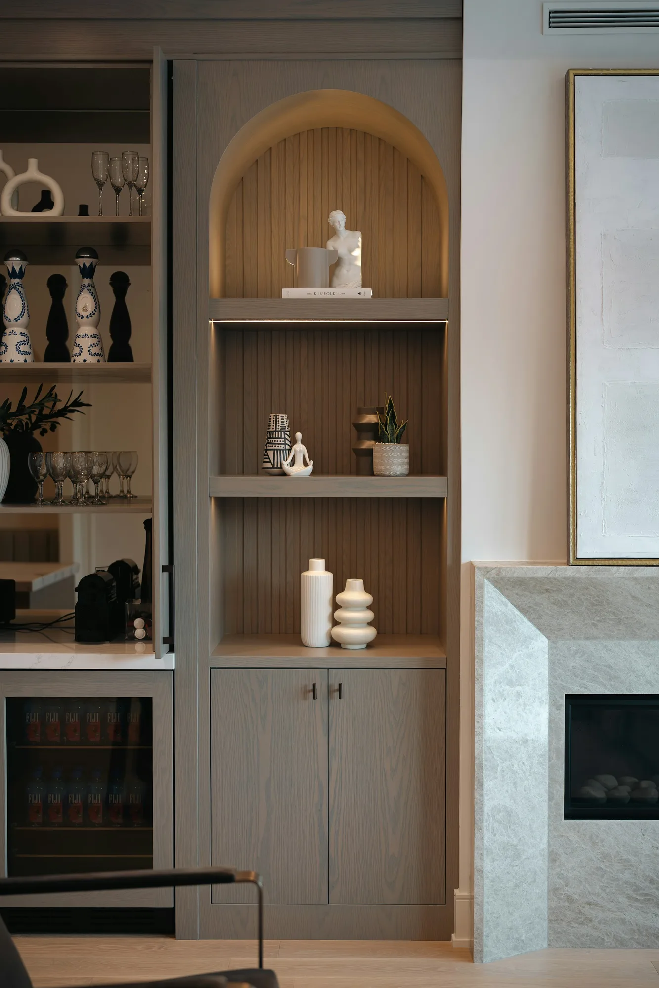Built-in living room shelving with decorative objects and warm accent lighting
