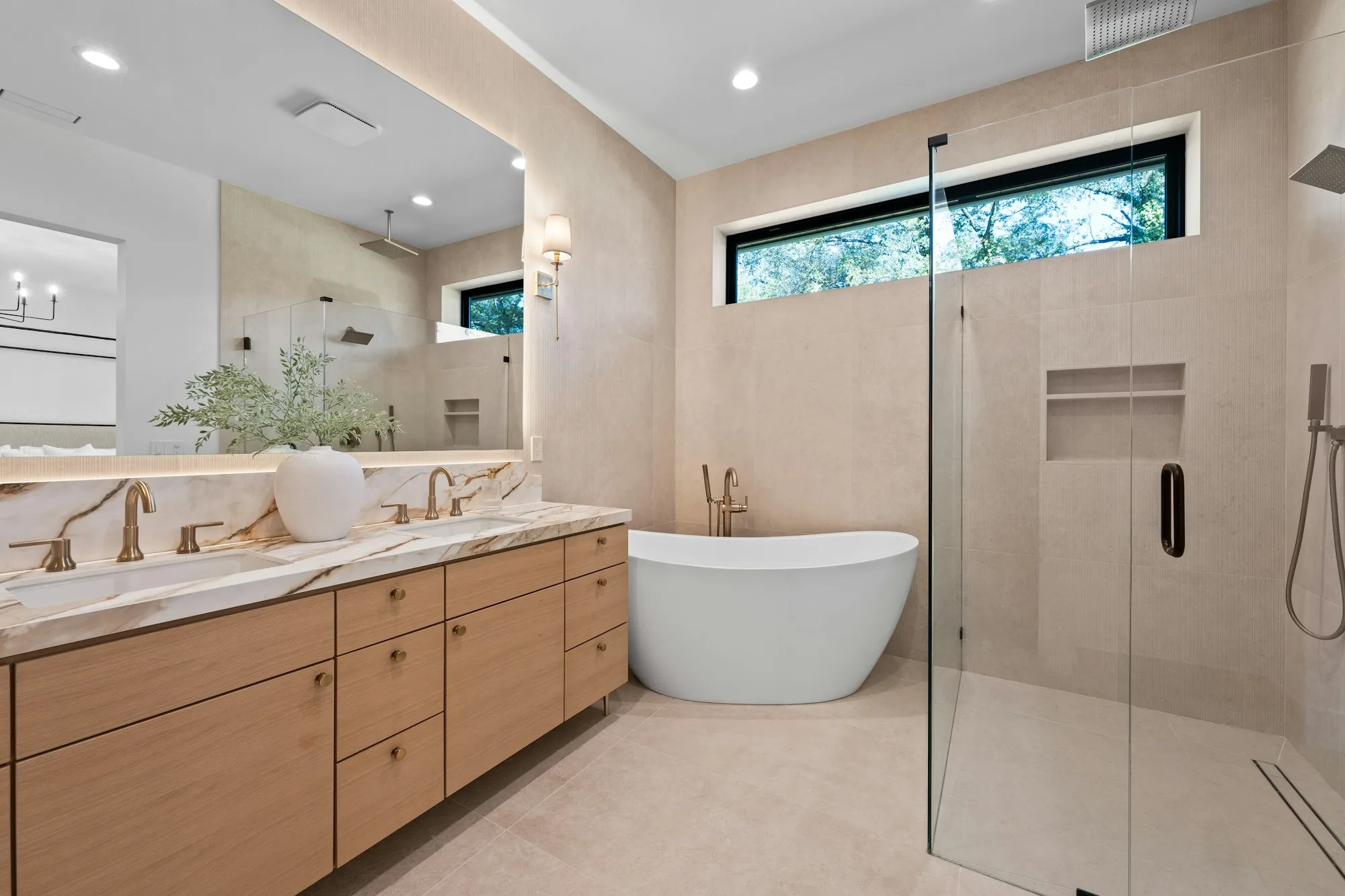 Modern bathroom with oak double vanity, marble countertop and freestanding tub