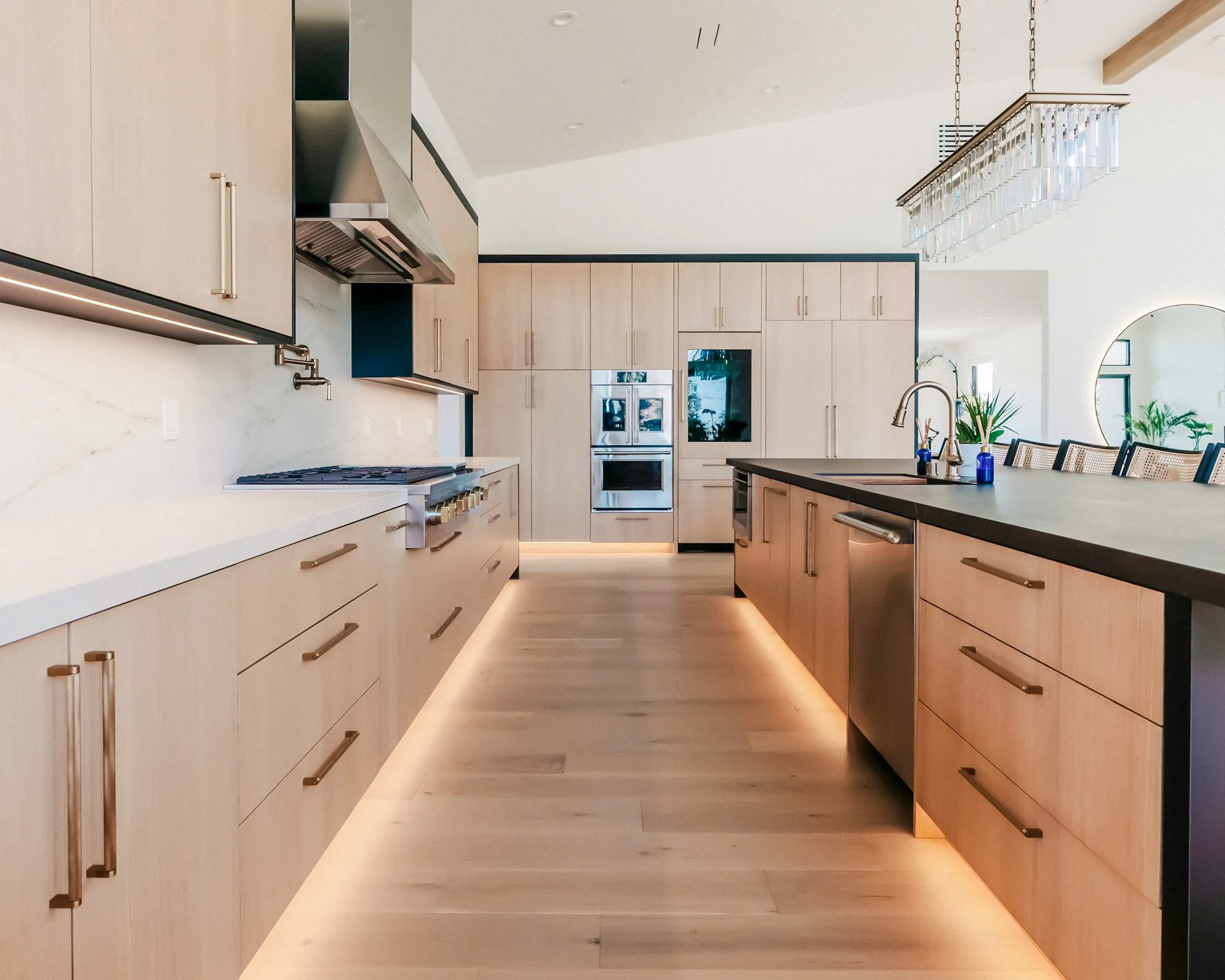 Modern kitchen with light oak cabinets, a broad island and black framed windows