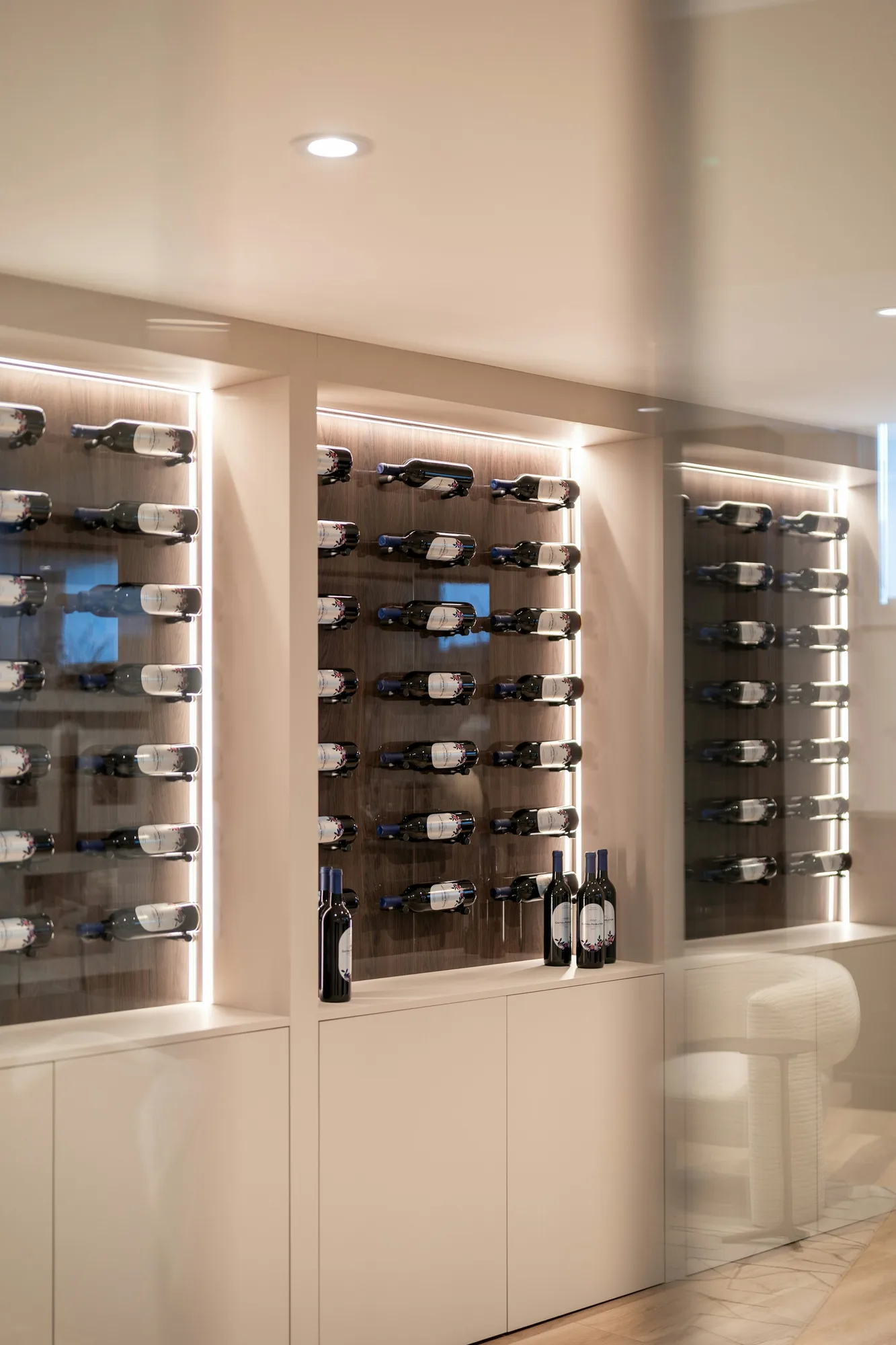 Contemporary wine cellar with illuminated bottle racks and display shelves